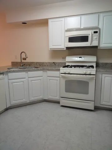 a kitchen with stainless steel appliances granite countertop a stove microwave and sink