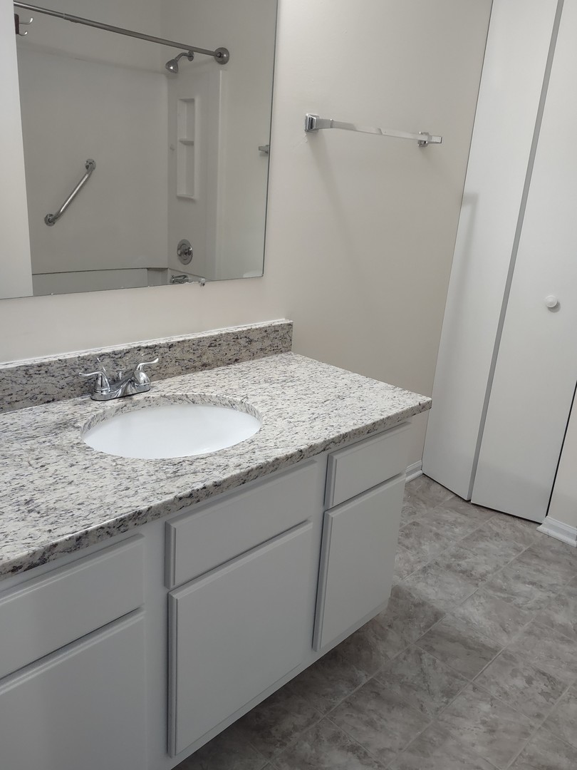 23 Taylor Court, Unit A Streamwood, IL 60107 - Photo 10 of 20 a bathroom with a granite countertop sink and a mirror