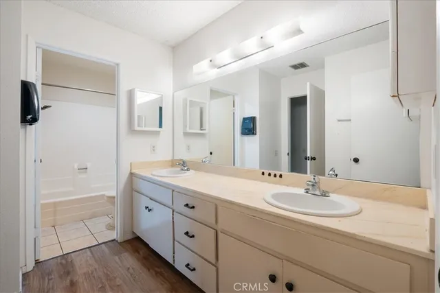 a bathroom with a sink double vanity granite tub shower and a mirror