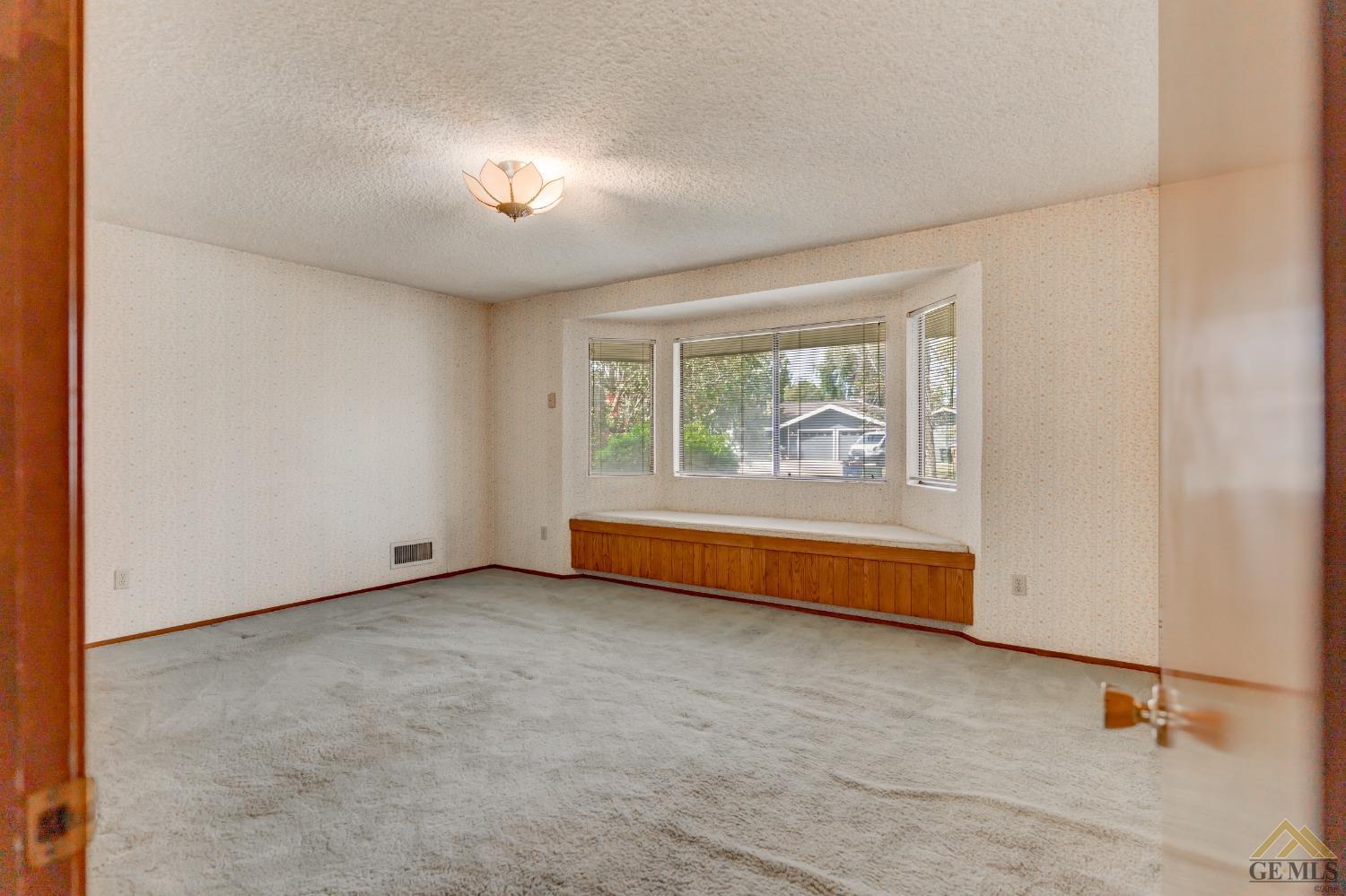 Undisclosed Address Bakersfield, CA 93309 - Photo 31 of 38 an empty room with chandelier fan and windows