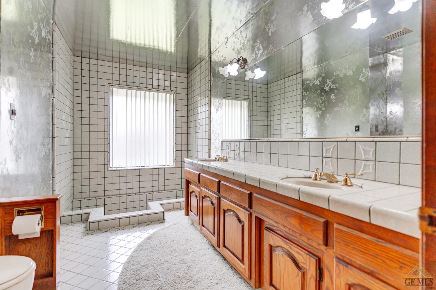 Undisclosed Address Bakersfield, CA 93309 - Photo 34 of 38 a bathroom with a sink a large mirror and a bathtub