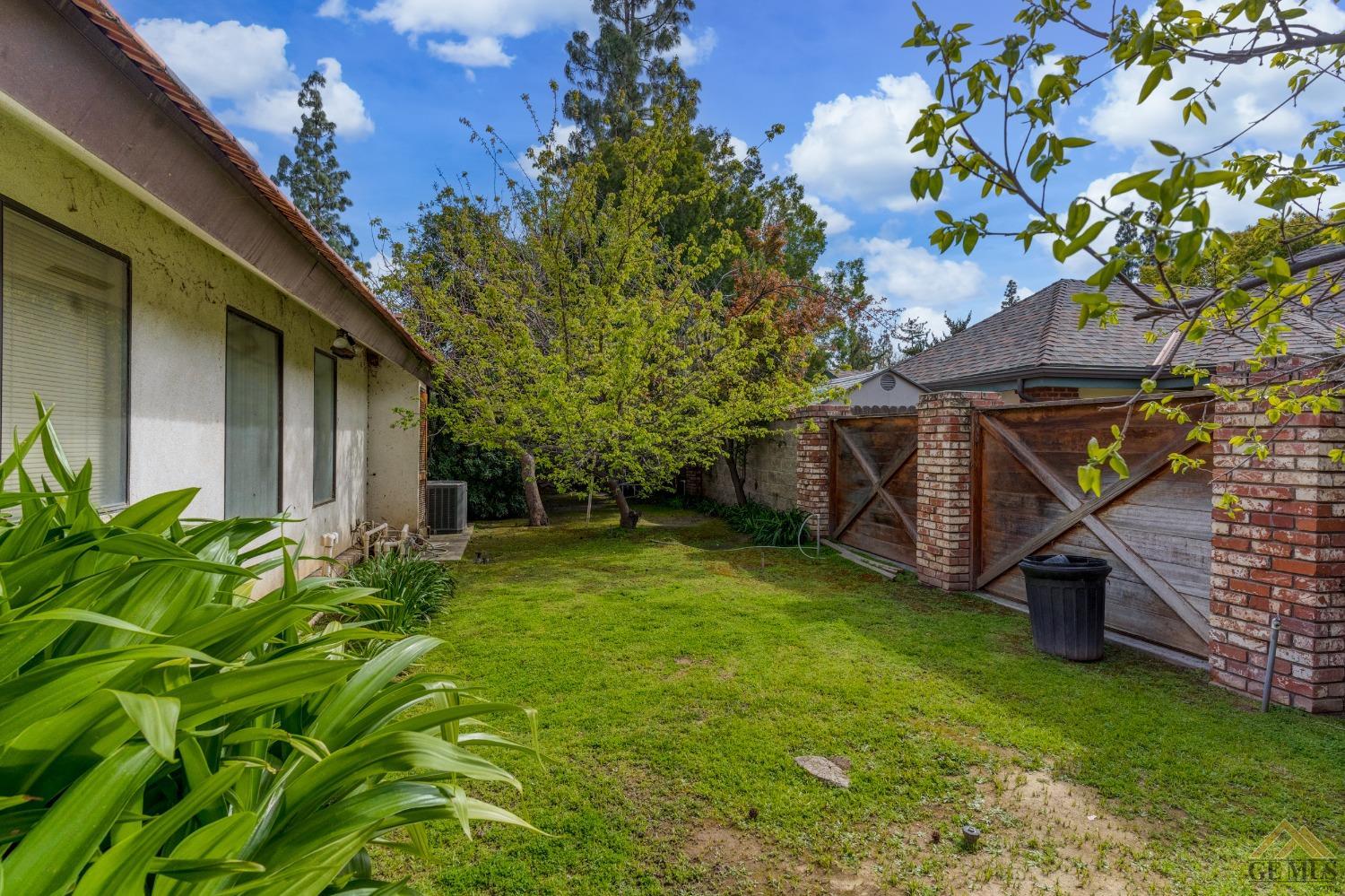 Undisclosed Address Bakersfield, CA 93309 - Photo 5 of 38 a view of a backyard with potted plants and large tree