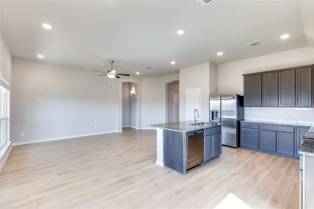 a kitchen with stainless steel appliances kitchen island granite countertop a sink and a stove top oven