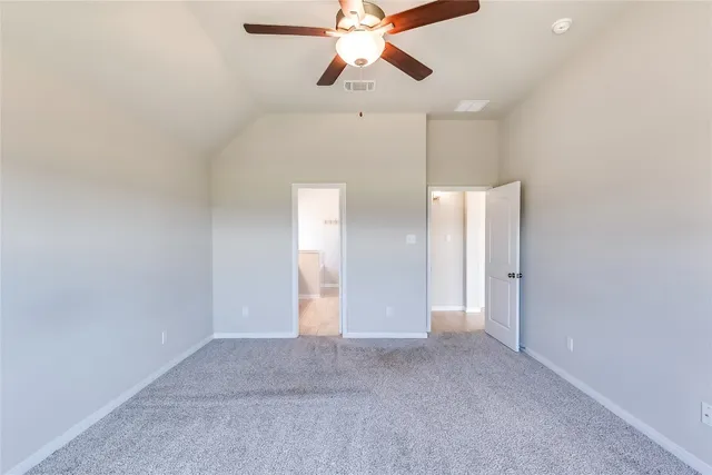 a view of an empty room and chandelier fan