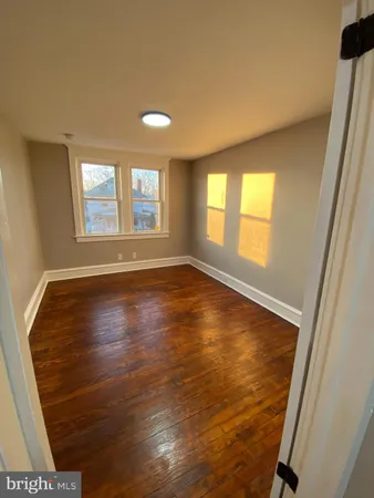 an empty room with a hardwood and a window