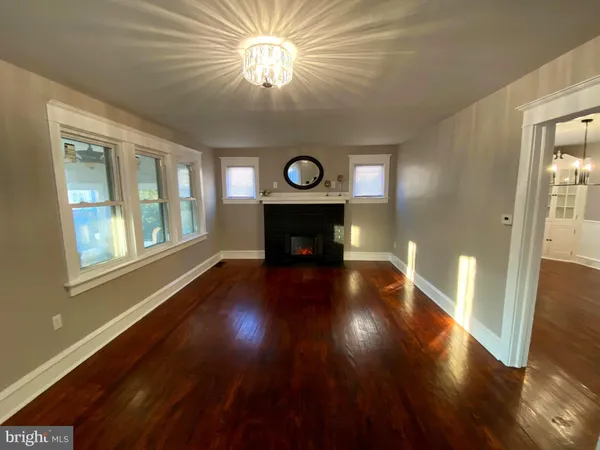 a view of a room with wooden floor staircase and a kitchen