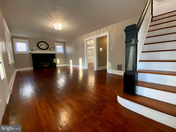 a living room with a fireplace and a wooden floor