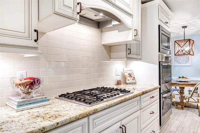 a kitchen with stainless steel appliances granite countertop a sink stove and cabinets