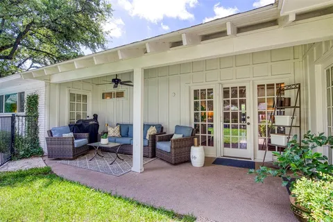 a view of a patio with couches table and chairs and potted plants