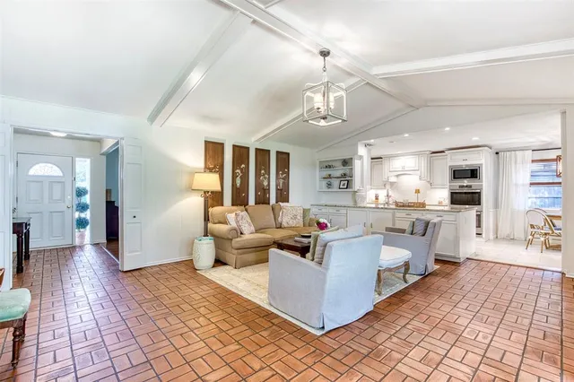 a living room with furniture and view of kitchen