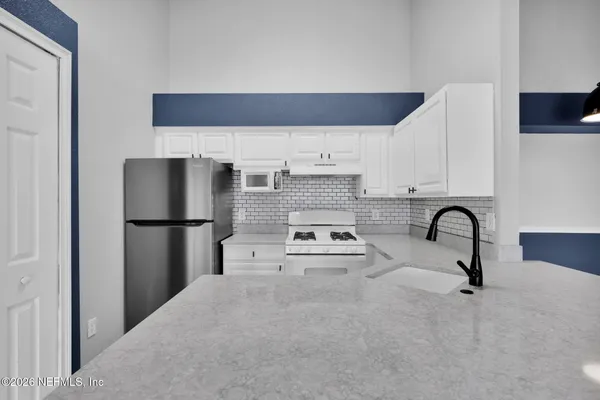 a kitchen with a sink cabinets and appliances