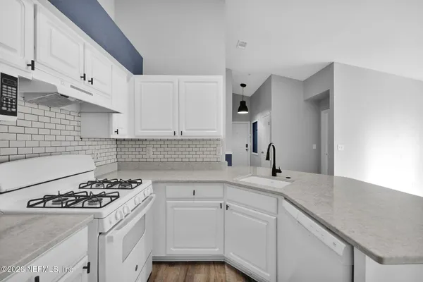 a kitchen with a sink cabinets and wooden floor