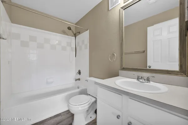 an empty room with windows and ceiling fan