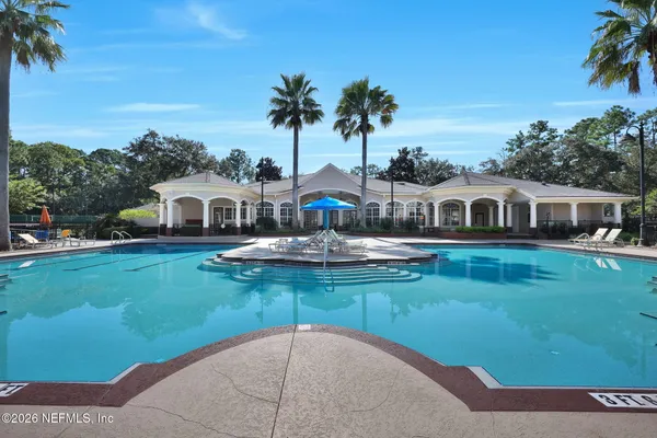 a view of swimming pool with large trees and plants