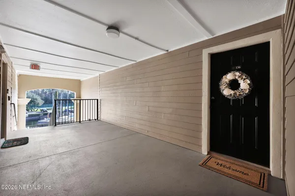 a view of a hallway to a livingroom with wooden floor and a chandelier