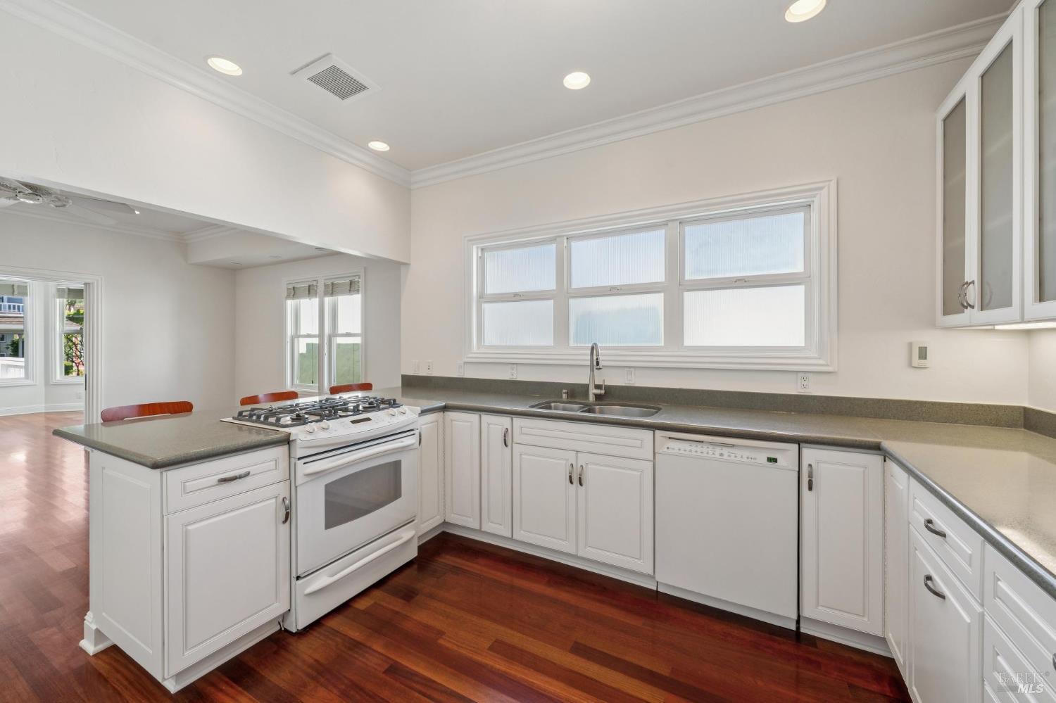 102 F Street San Rafael, CA 94901 - Photo 18 of 80 a kitchen with granite countertop white cabinets and white appliances