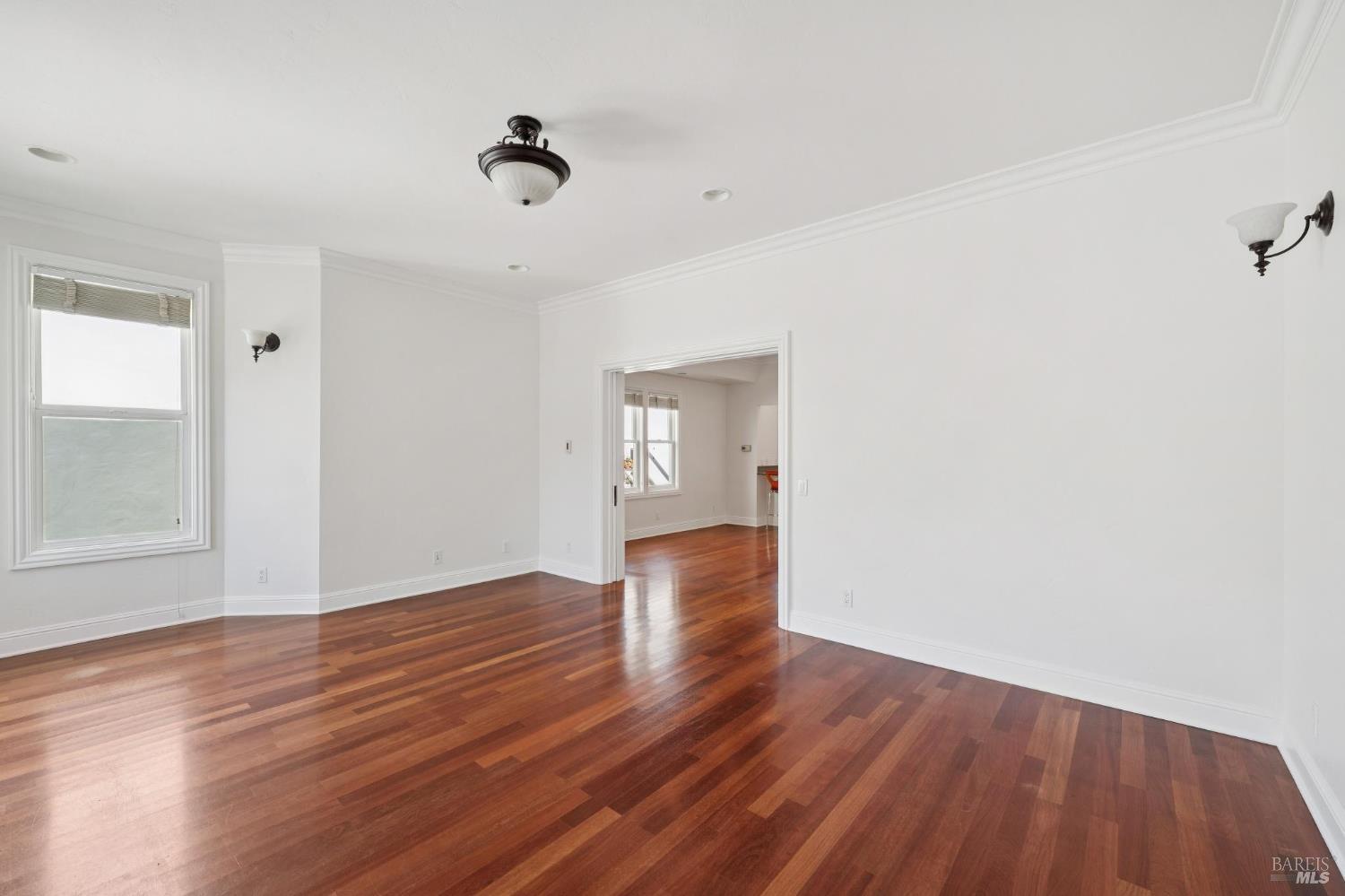 102 F Street San Rafael, CA 94901 - Photo 6 of 80 a view of an empty room with wooden floor and a window