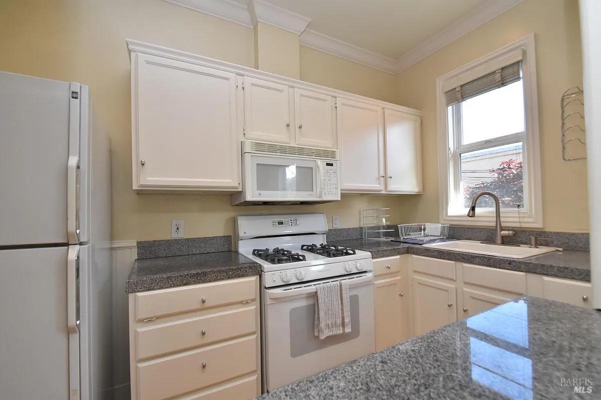 102 F Street San Rafael, CA 94901 - Photo 65 of 80 a kitchen with granite countertop white cabinets and white appliances