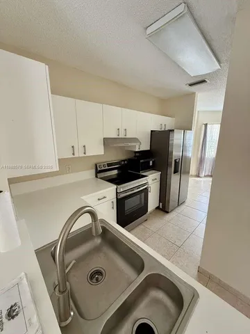 a kitchen with a sink a stove and refrigerator
