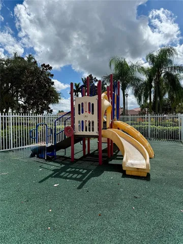 a view of a park with slide and potted plants
