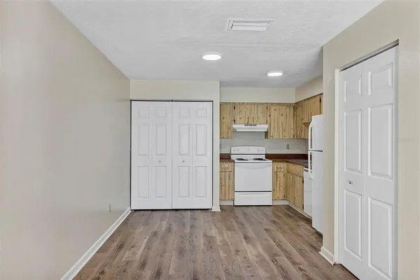 a kitchen with a refrigerator and white cabinets