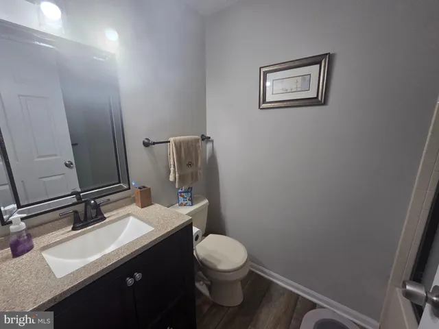 a bathroom with a sink vanity mirror and toilet