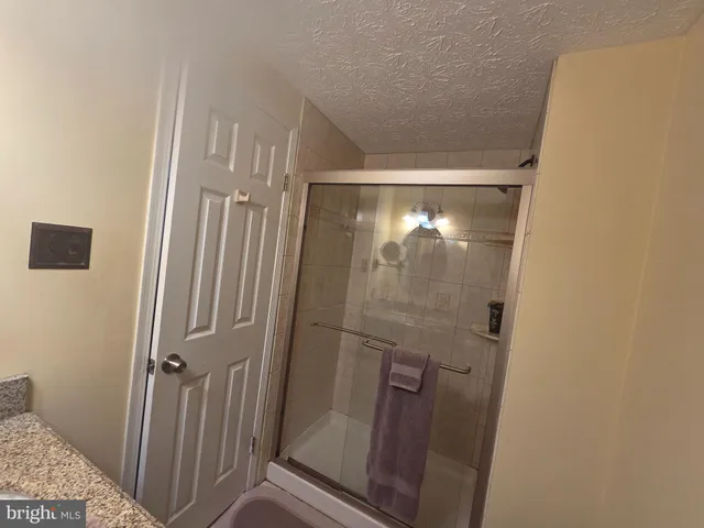 a bathroom with a glass door shower and vanity