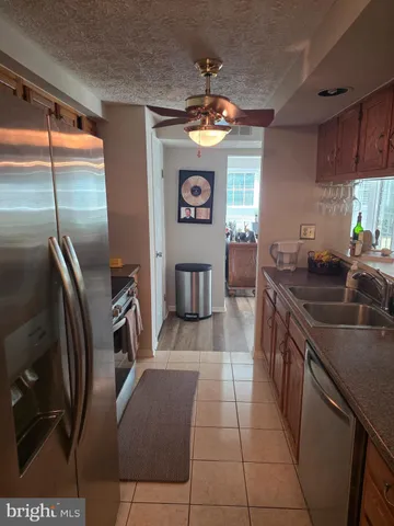 a kitchen with stainless steel appliances granite countertop a sink a stove top oven a counter space and cabinets