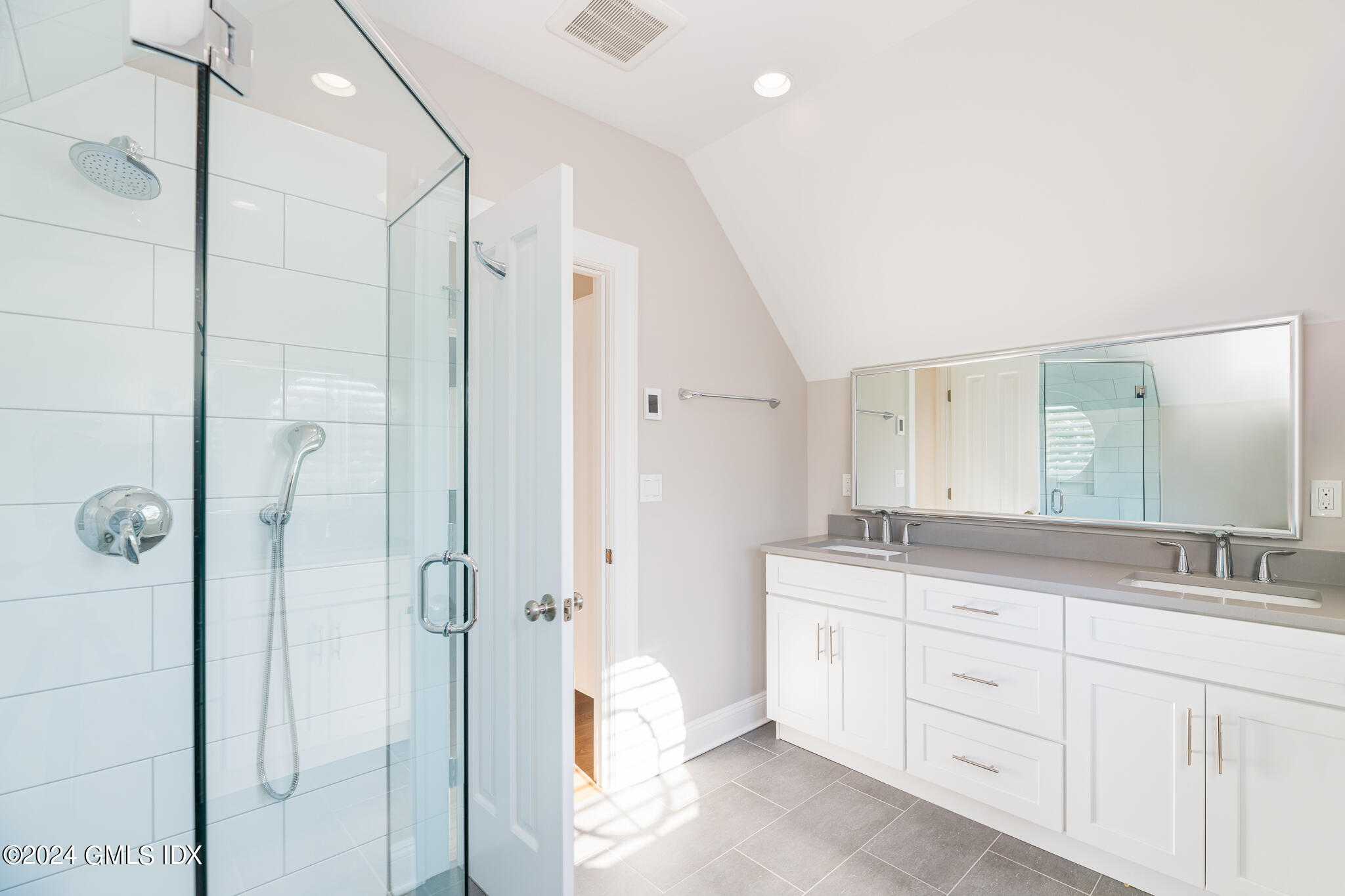 550 River Road Cos Cob, CT 06807 - Photo 19 of 32 a spacious bathroom with a granite countertop sink a mirror a shower and a bathtub