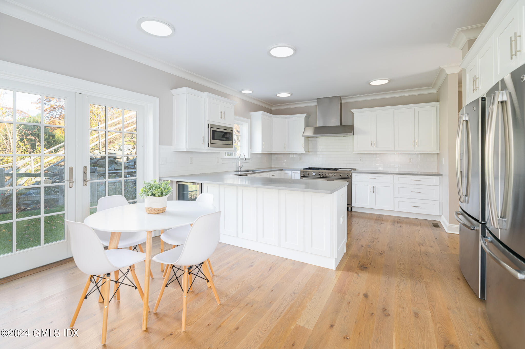 550 River Road Cos Cob, CT 06807 - Photo 8 of 32 a kitchen with stainless steel appliances kitchen island granite countertop a refrigerator a stove a sink and white cabinets with wooden floor