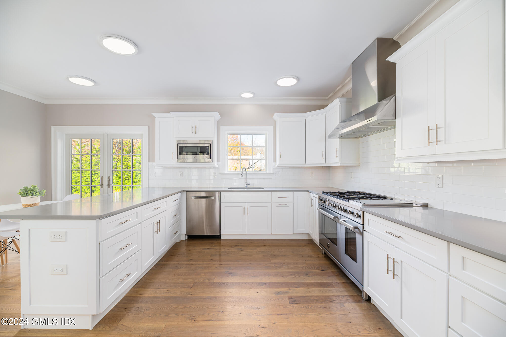 550 River Road Cos Cob, CT 06807 - Photo 9 of 32 a kitchen with white cabinets and white appliances