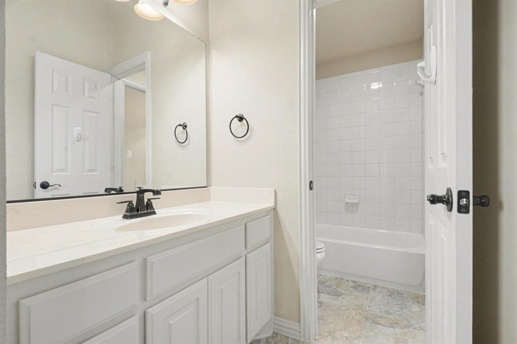 708 Yarrow Street Little Elm, TX 75068 - Photo 17 of 26 a bathroom with a bathtub sink vanity and mirror