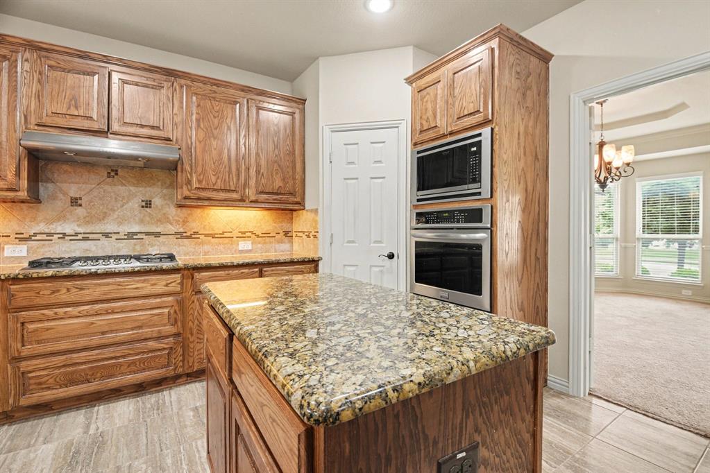 708 Yarrow Street Little Elm, TX 75068 - Photo 8 of 26 a kitchen with granite countertop stainless steel appliances and granite counter tops