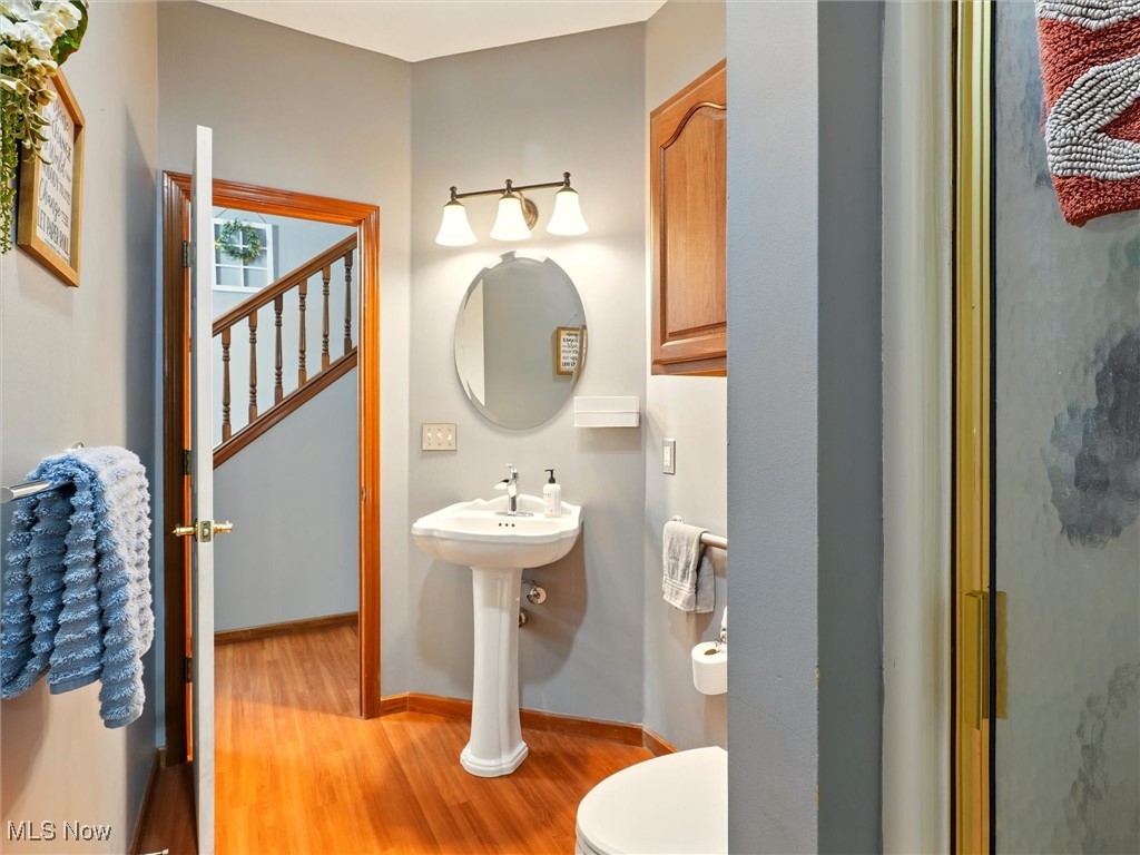 2068 Chimney Ridge Drive Madison, OH 44057 - Photo 13 of 37 Main floor full bathroom featuring toilet, wood finished floors, and baseboards