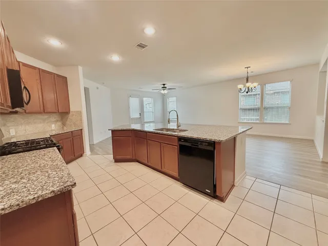 a large kitchen with stainless steel appliances granite countertop a stove and a sink