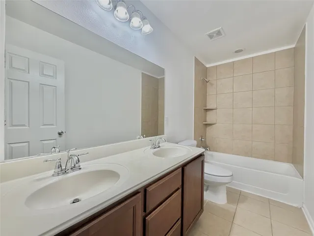 a bathroom with a sink a toilet a mirror and bathtub