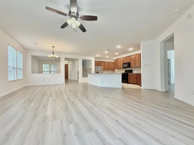 a view of a living room and kitchen with wooden floor