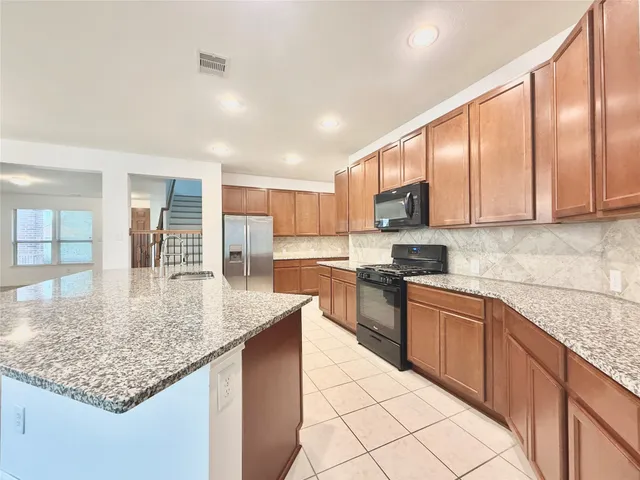a kitchen with stainless steel appliances granite countertop a sink dishwasher and cabinets with wooden floor