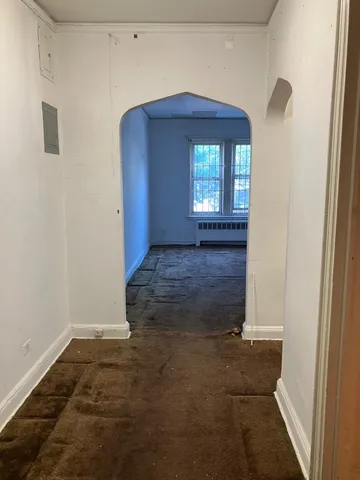 a view of a hallway with wooden floor and a window