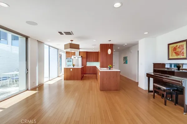 a large kitchen with stainless steel appliances kitchen island granite countertop a refrigerator a oven and a sink with wooden cabinets