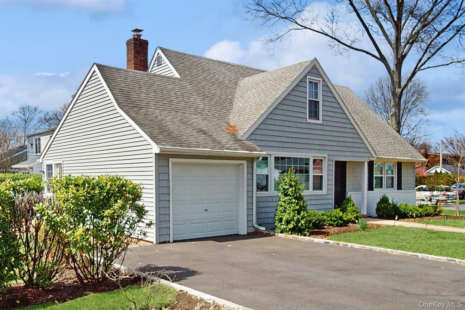 170 Wetherill Road Garden City, NY 11530 - Photo 2 of 23 New england style home with a garage, driveway, a chimney, and a shingled roof