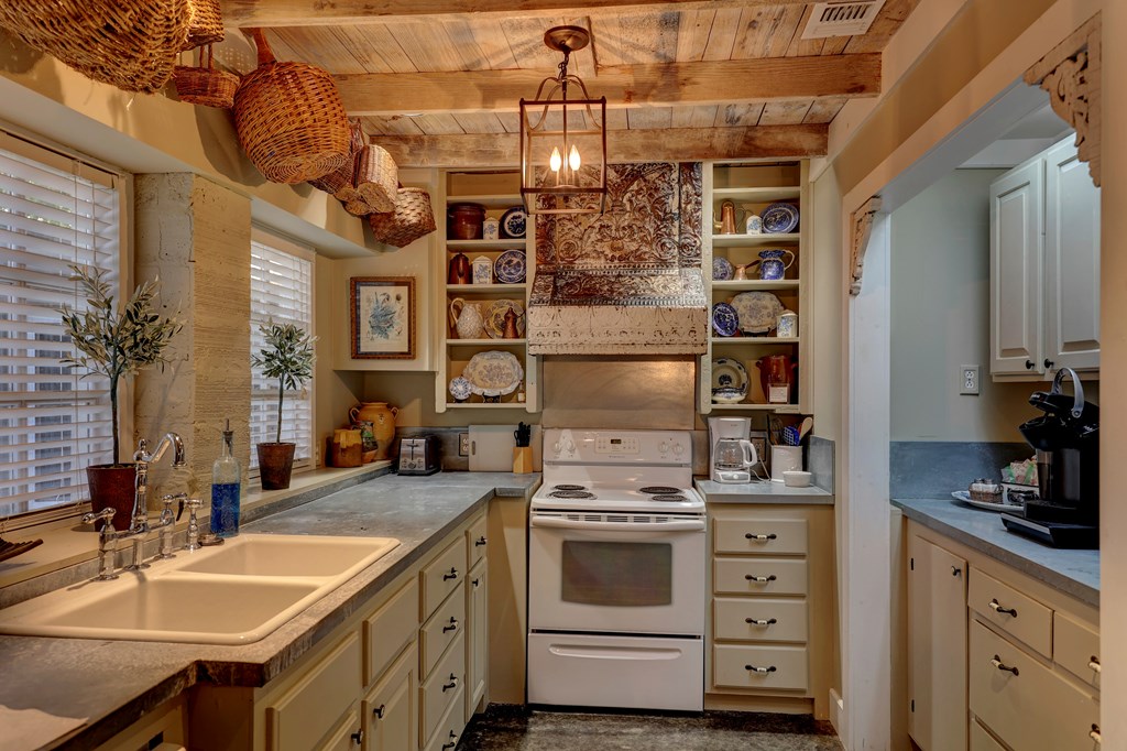3965 Highway 27 Kerrville, TX 78028 - Photo 51 of 62 a kitchen that has a stove a sink and dishwasher with white cabinets