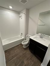563 Evergreen Sumac Loop Kyle, TX 78640 - Photo 15 of 18 A well-lit full bathroom boasts durable wood-look flooring and a functional shower-tub combination.