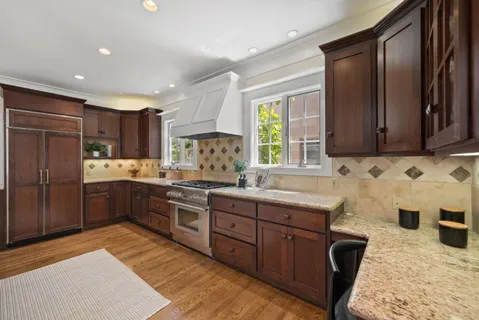 a large kitchen with lots of counter space a sink appliances and cabinets