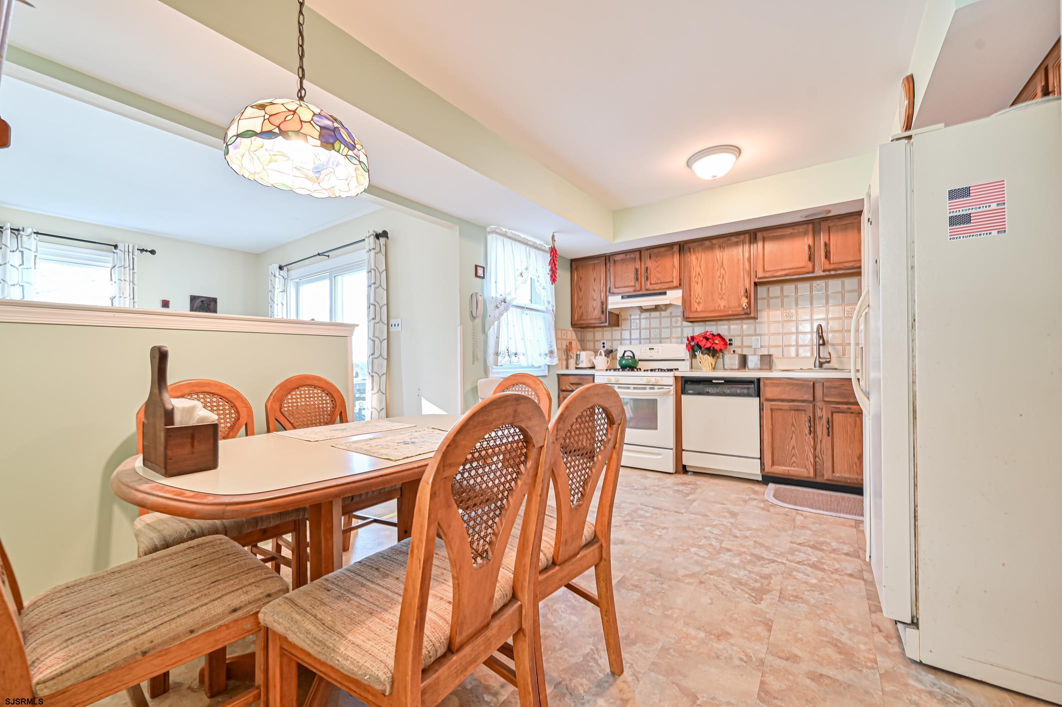 16 MacDermott Place Brigantine, NJ 08203 - Photo 11 of 37 a kitchen with a dining table chairs and refrigerator