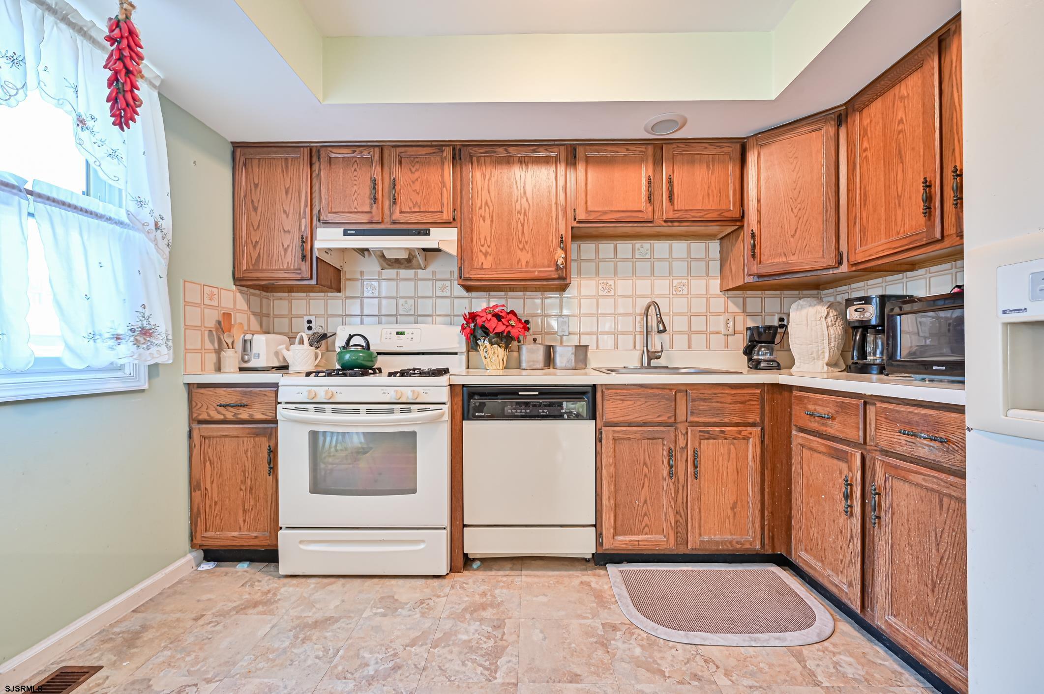 16 MacDermott Place Brigantine, NJ 08203 - Photo 13 of 37 a kitchen with stainless steel appliances granite countertop a stove sink and cabinets