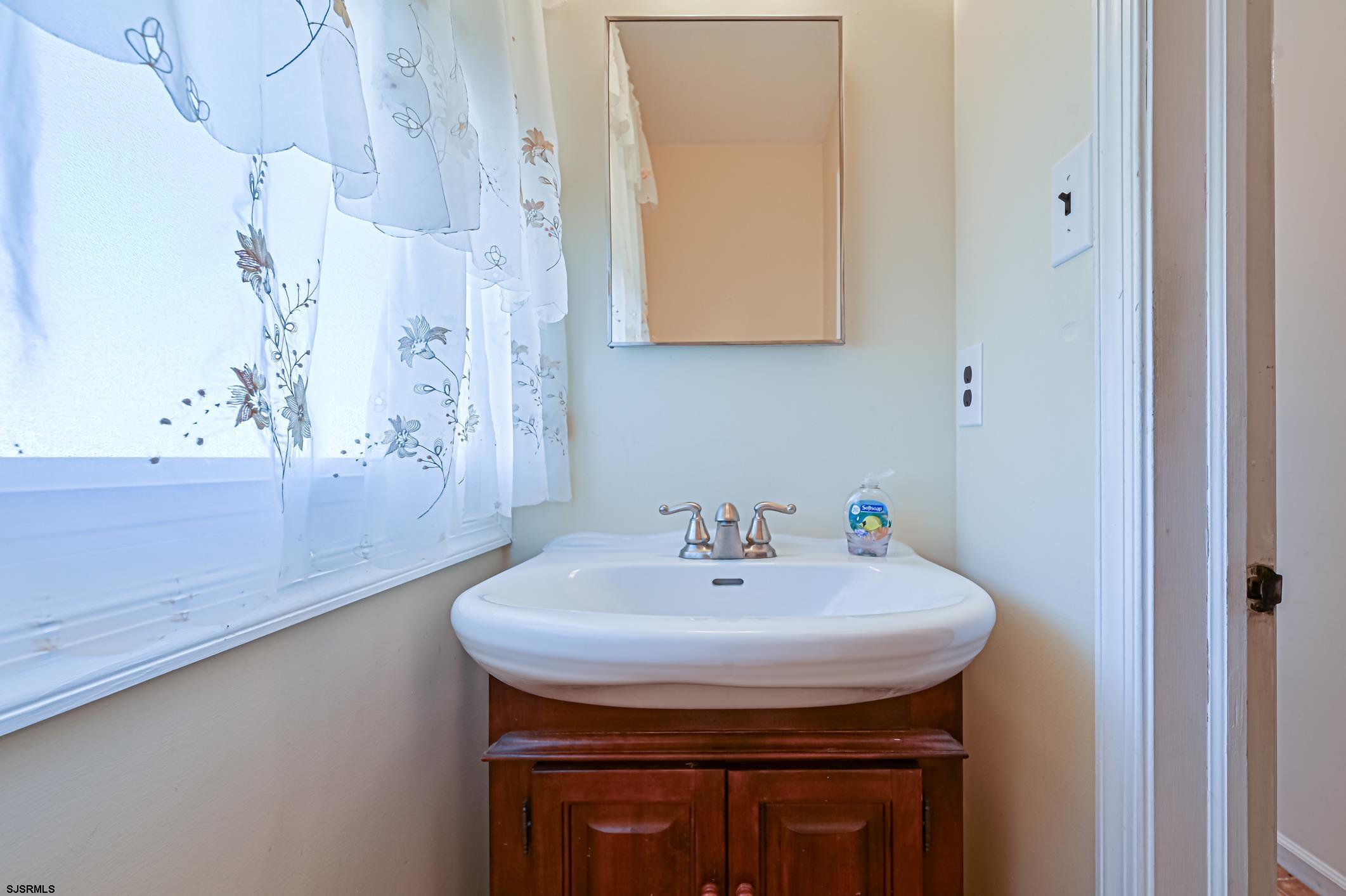 16 MacDermott Place Brigantine, NJ 08203 - Photo 15 of 37 a bathroom with a sink and a mirror