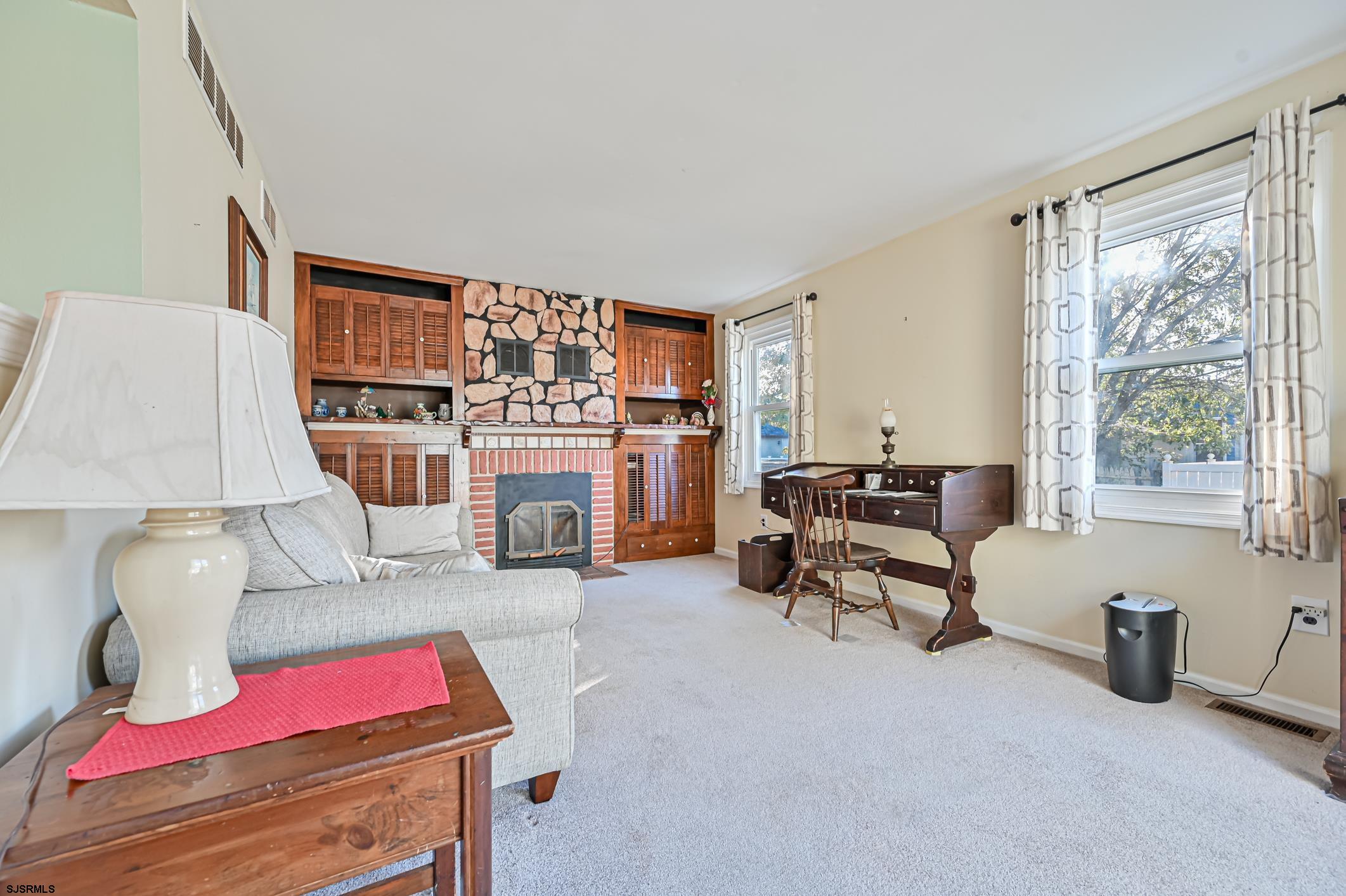 16 MacDermott Place Brigantine, NJ 08203 - Photo 17 of 37 a living room with furniture a fireplace and a table