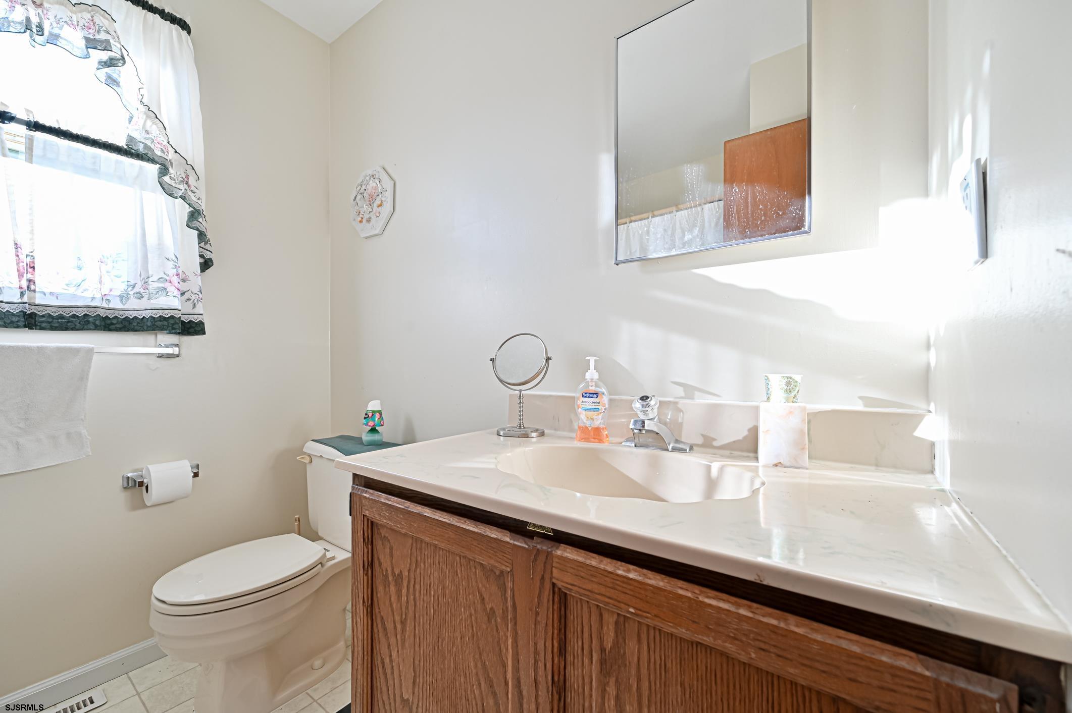 16 MacDermott Place Brigantine, NJ 08203 - Photo 24 of 37 a bathroom with a sink a toilet and mirror