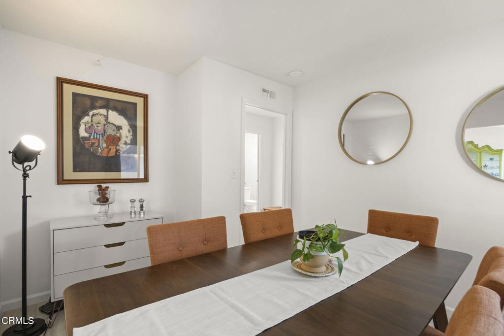 400 Dewberry Lane, Unit 101 Oxnard, CA 93036 - Photo 14 of 37 a view of a dining room with furniture a potted plant and wooden floor